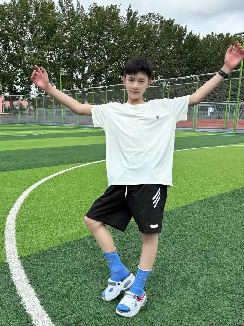 Chàng trai dễ thương tuổi vẫy tay trên sân cỏ xanh mướt Chàng trai dễ thương tuổi vẫy tay trên sân cỏ xanh mướt