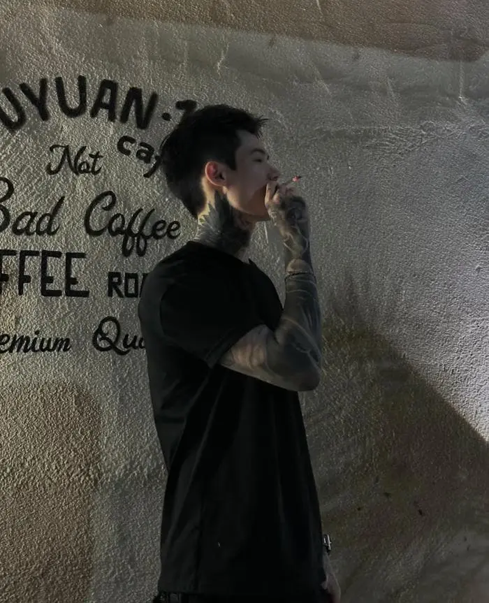 Chàng trai phong trổ hình xăm cá tính đang hút thuốc lá Chàng trai phong trổ hình xăm cá tính đang hút thuốc lá