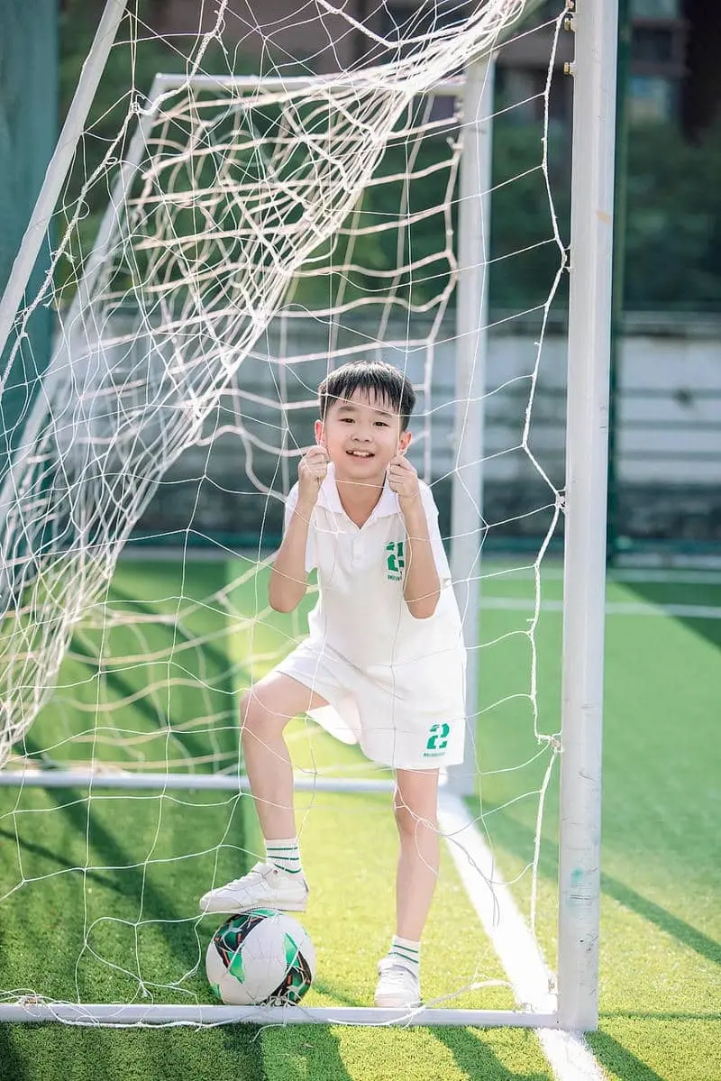 Chàng trai xinh xắn tuổi hào hứng bên khung thành bóng đá Chàng trai xinh xắn tuổi hào hứng bên khung thành bóng đá